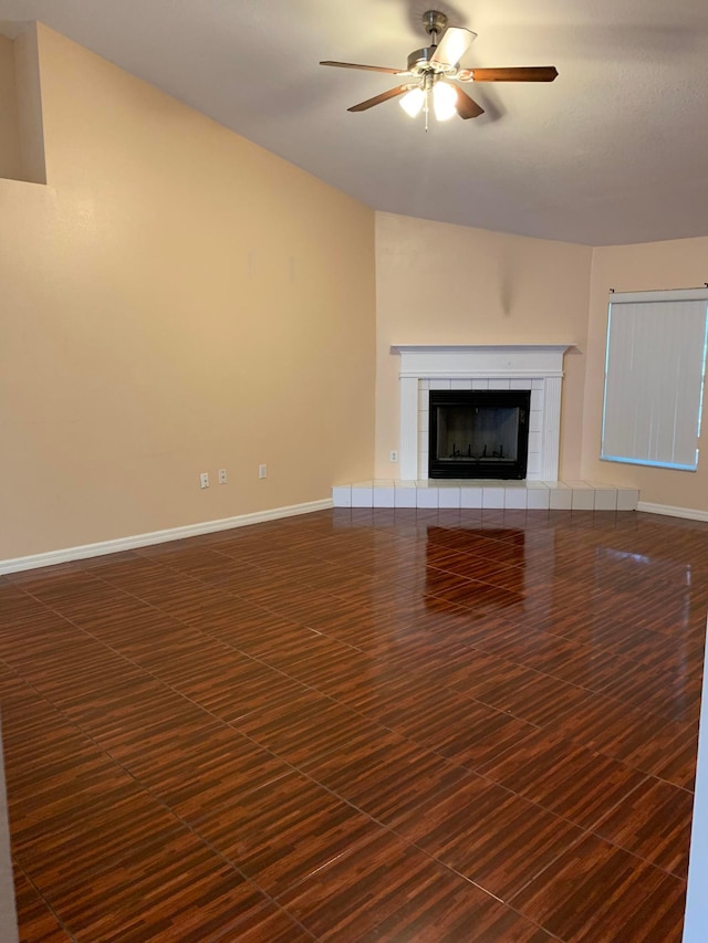 unfurnished living room featuring a tile fireplace and ceiling fan