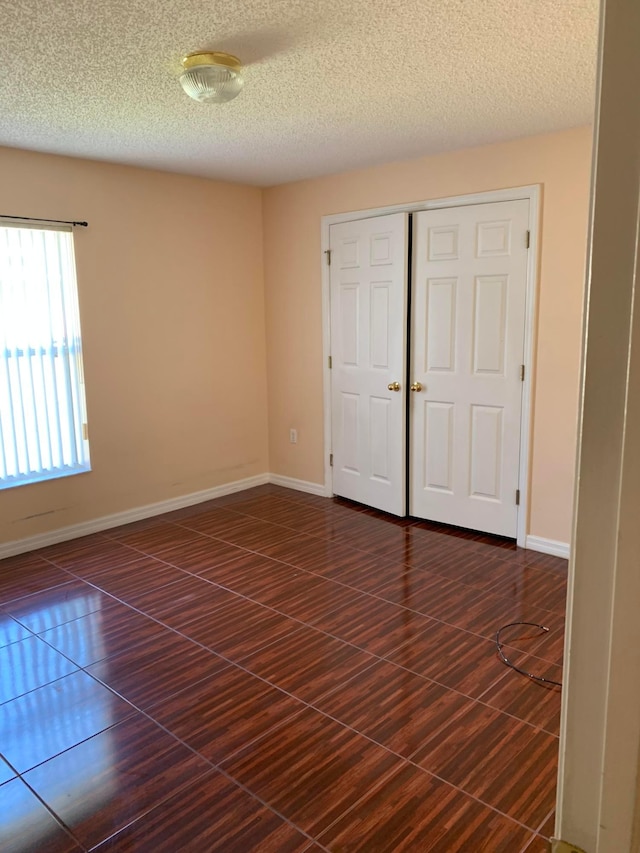 spare room with dark tile flooring and a textured ceiling