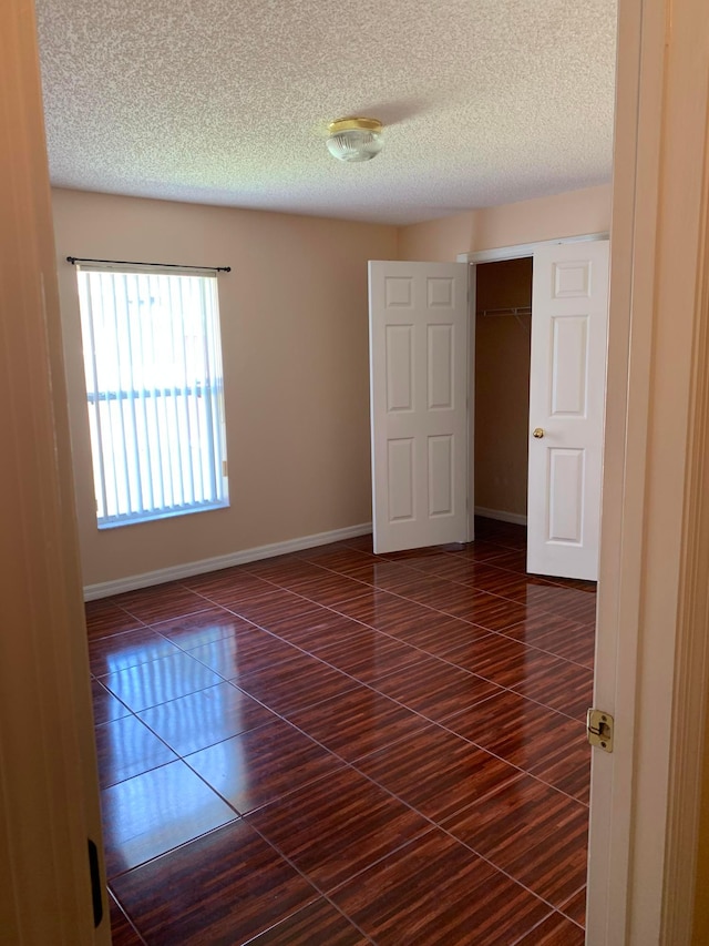 empty room featuring dark tile floors and a textured ceiling