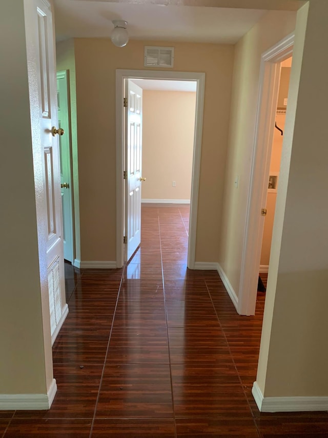 hall with dark tile flooring