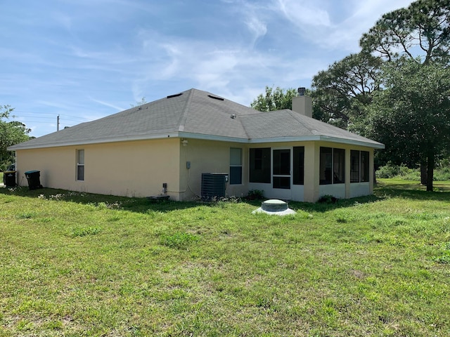 back of property with a sunroom and a lawn