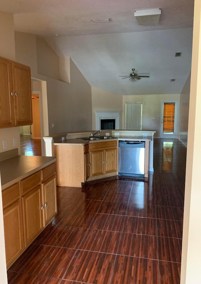 kitchen featuring lofted ceiling, ceiling fan, sink, dishwasher, and dark tile flooring