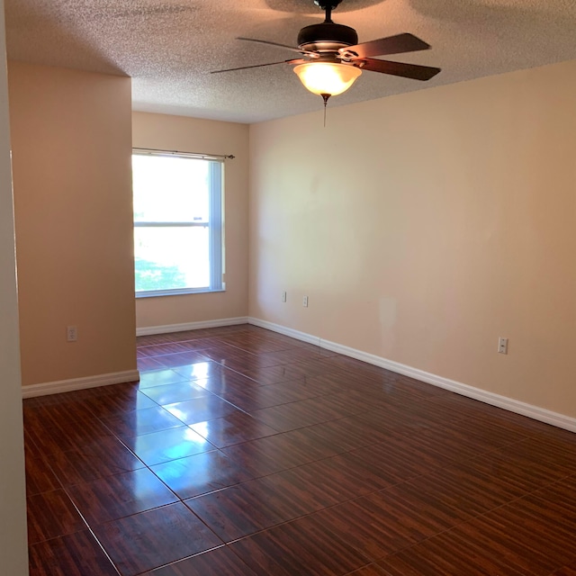 tiled spare room with a textured ceiling and ceiling fan