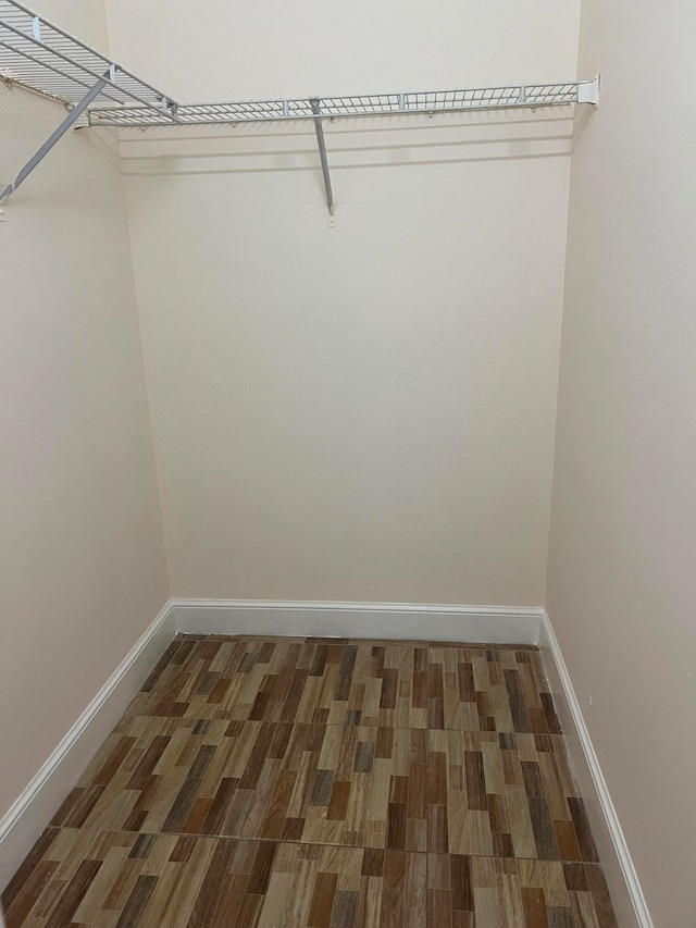 walk in closet with dark wood-type flooring