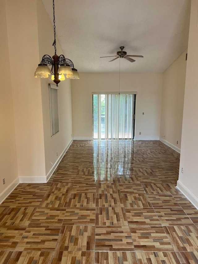 empty room with ceiling fan with notable chandelier