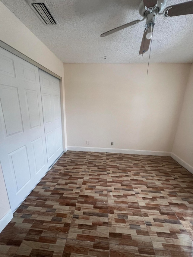 unfurnished bedroom with ceiling fan, a textured ceiling, and a closet