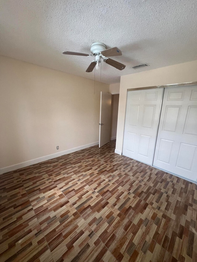 unfurnished bedroom with ceiling fan, a closet, and a textured ceiling