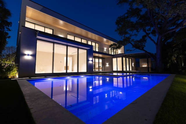 view of pool at twilight