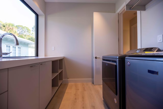 laundry room featuring washer and dryer and light hardwood / wood-style flooring