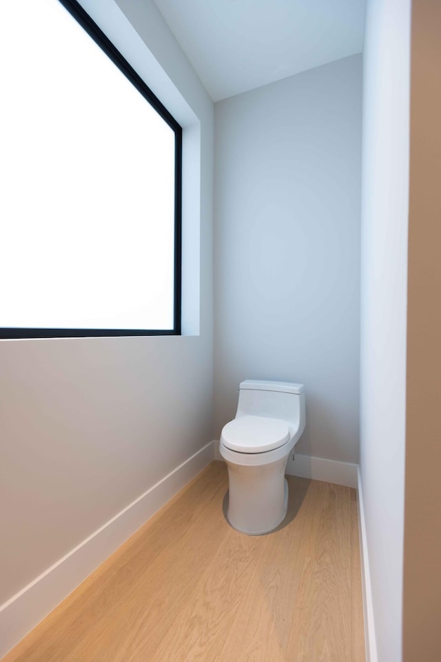 bathroom featuring hardwood / wood-style floors, a healthy amount of sunlight, and toilet