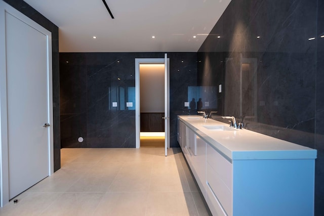 kitchen featuring light tile floors, white cabinetry, sink, and tile walls