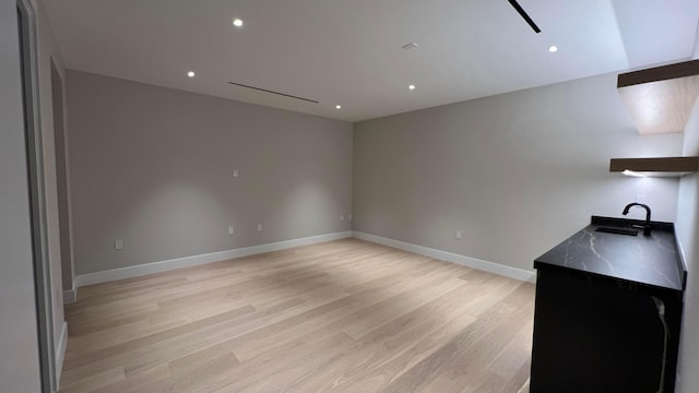 unfurnished room with light hardwood / wood-style floors and sink