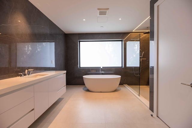 bathroom with vanity, plus walk in shower, tile floors, and tile walls