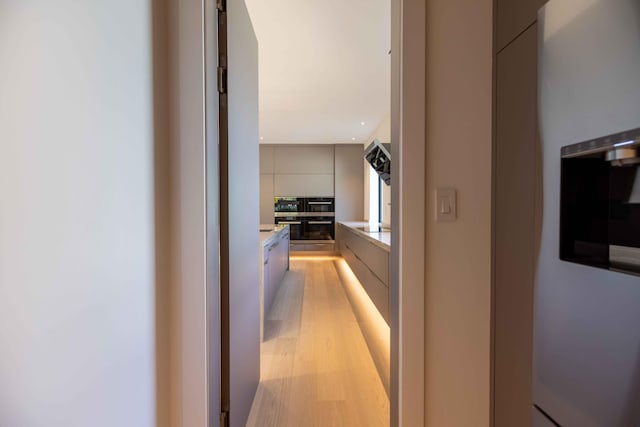 corridor with light hardwood / wood-style flooring