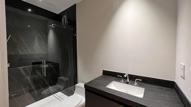 bathroom with vanity, a shower with door, and toilet