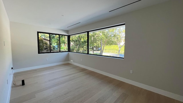 empty room with plenty of natural light and light hardwood / wood-style flooring