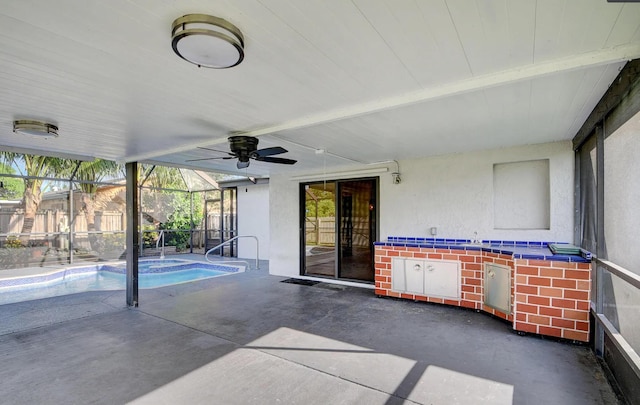 view of patio with glass enclosure and ceiling fan