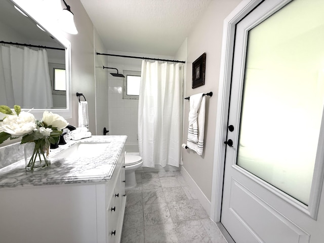 bathroom with vanity, baseboards, shower / bath combo, a textured ceiling, and toilet