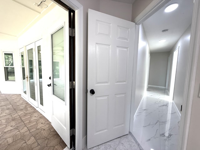 corridor featuring french doors, baseboards, and marble finish floor