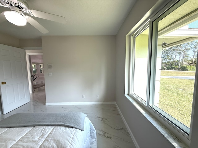 unfurnished bedroom featuring baseboards, marble finish floor, and a ceiling fan