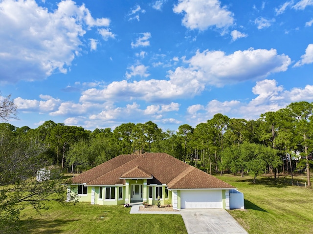 mediterranean / spanish-style house featuring a garage, a front lawn, roof with shingles, and driveway