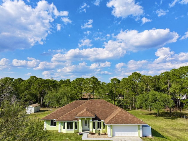 view of front facade featuring an attached garage, driveway, and a front yard