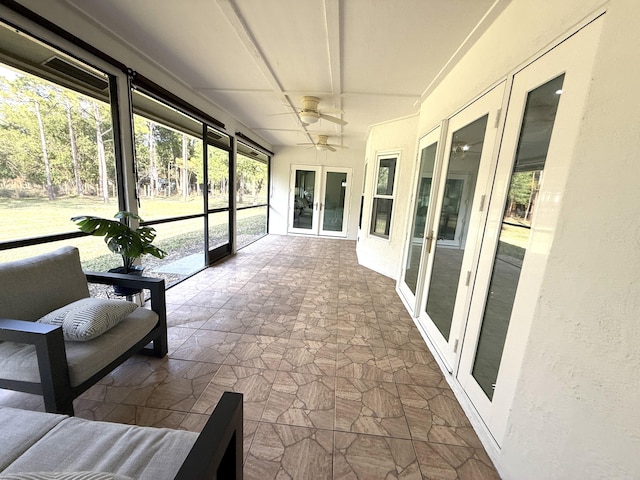 unfurnished sunroom with ceiling fan