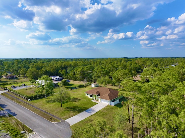 drone / aerial view featuring a wooded view