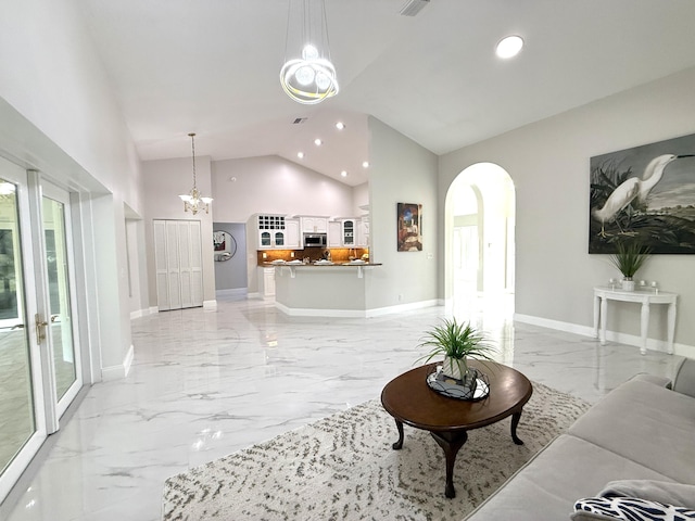 living area with arched walkways, a chandelier, marble finish floor, and baseboards