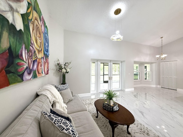 living room featuring a notable chandelier, marble finish floor, a textured ceiling, french doors, and baseboards