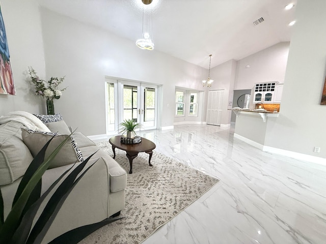 living area featuring baseboards, visible vents, marble finish floor, and a chandelier