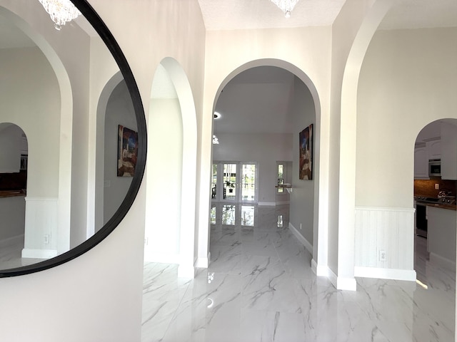 corridor featuring marble finish floor and wainscoting