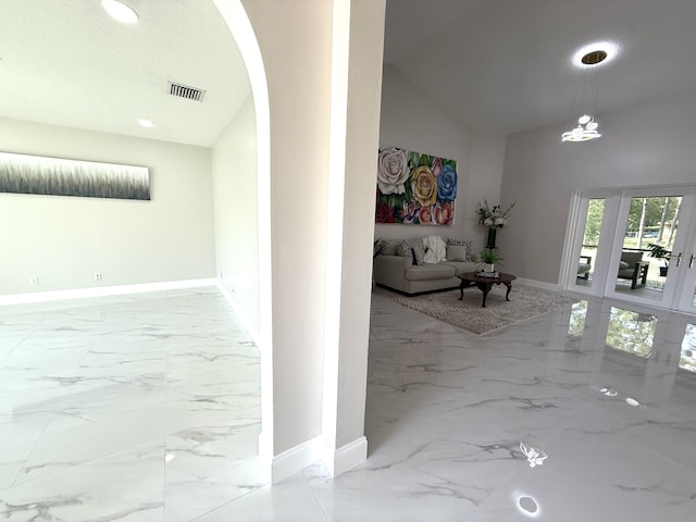 hall with baseboards, visible vents, high vaulted ceiling, arched walkways, and marble finish floor