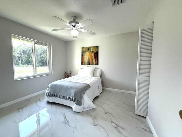 bedroom featuring visible vents, baseboards, a textured ceiling, and marble finish floor