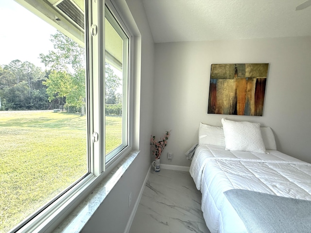 bedroom featuring baseboards, marble finish floor, and a textured ceiling