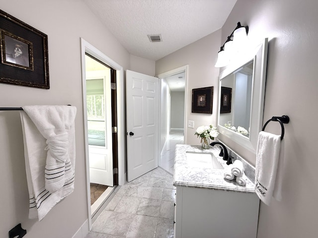 bathroom with vanity, visible vents, marble finish floor, and a textured ceiling