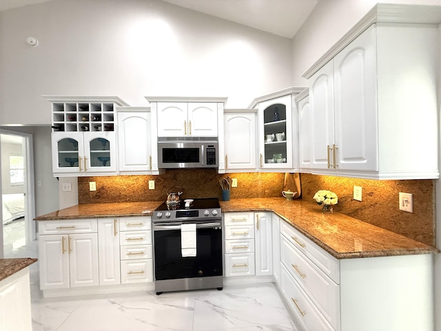 kitchen featuring marble finish floor, dark stone countertops, appliances with stainless steel finishes, and glass insert cabinets