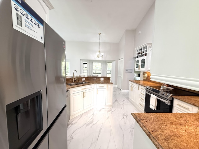 kitchen with a sink, range with electric cooktop, white cabinets, marble finish floor, and stainless steel fridge