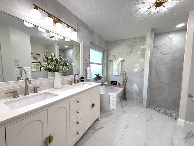 bathroom featuring a sink, a textured ceiling, marble finish floor, and a freestanding bath