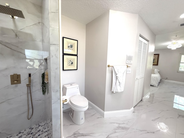 bathroom with a marble finish shower, baseboards, ensuite bath, marble finish floor, and a textured ceiling