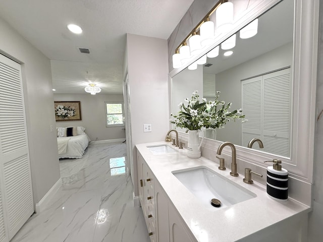 bathroom with a sink, a closet, baseboards, and marble finish floor