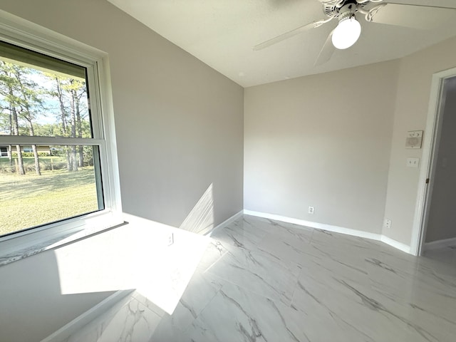 empty room with baseboards, marble finish floor, and a ceiling fan