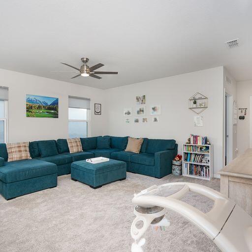 carpeted living room featuring plenty of natural light and ceiling fan