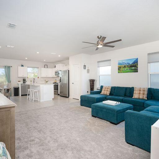 living room with ceiling fan and sink