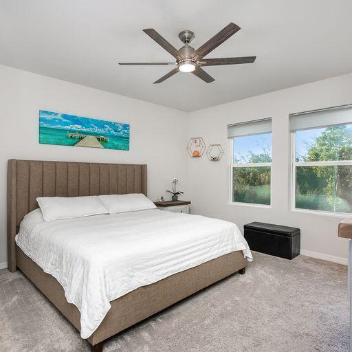 bedroom featuring light colored carpet and ceiling fan