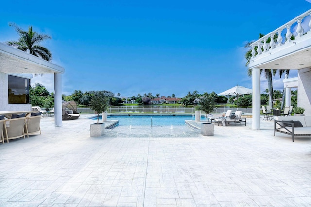 view of pool featuring a patio and a water view