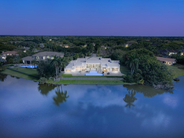 aerial view at dusk featuring a water view