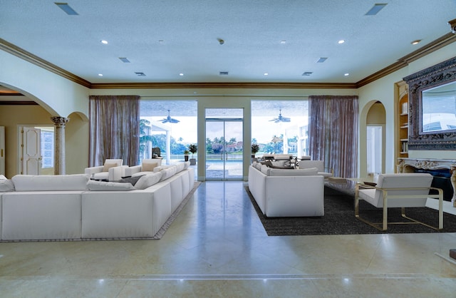 living room with a textured ceiling, plenty of natural light, crown molding, and built in features