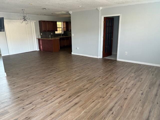 unfurnished living room featuring dark wood-type flooring and a textured ceiling