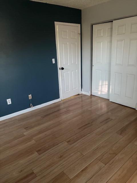 unfurnished bedroom with hardwood / wood-style floors and a closet